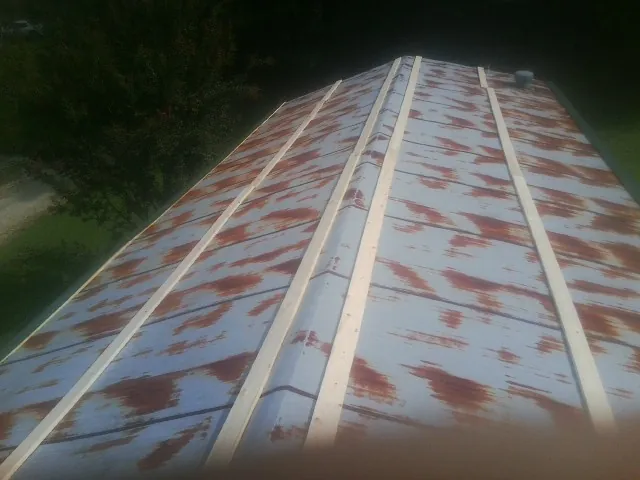 Rusted metal roof panels with new wood purlins before replacement — Storm Damage Roof Repair in Crabtree by Roofing Brothers